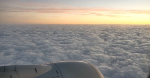 4k Luftaufnahme der Wolke bei Sonnenuntergang durch das Flugzeugfenster. — Stockvideo