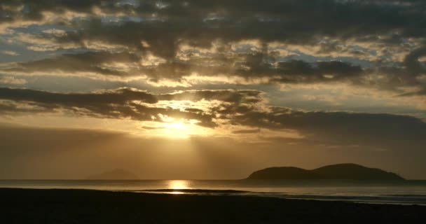 4k paisaje nublado y amanecer rompiendo a través de la nube sobre el reflejo del mar, rayos de dios . — Vídeos de Stock