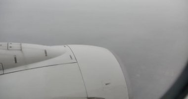 4k Havadan görülebilen bir şehir. Uçak penceresinden, bulutlu bir gün, hava.