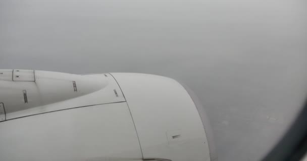 4k航空会社の窓、曇りの日、航空機を通してぼんやりと見える都市の空中ビュー — ストック動画