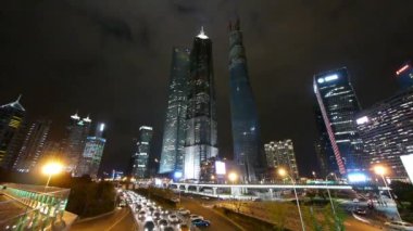 time lapse urban traffic & skyscraper,night illuminated cityscape skyline.