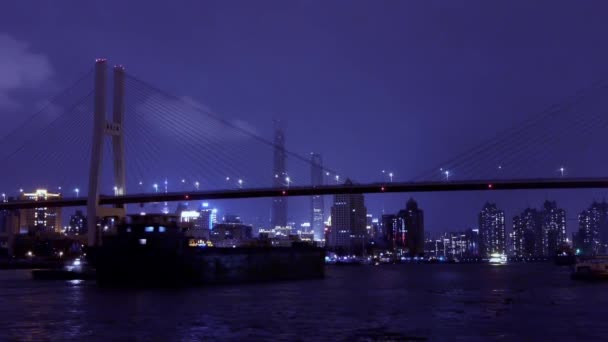 Busy shipping on river at night,across the sea bridge,Brightly urban building. — Stock Video