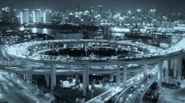 Karayolu kavşağında yoğun gece trafiği, parlak şehir manzarası, yoğun nakliyat