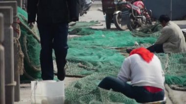 Çinli balıkçılar ağları onarıyor..