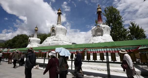 4k sípcsont emberek viszont forgó buddhista ima kerekek, Potala & fehér stupa. — Stock videók