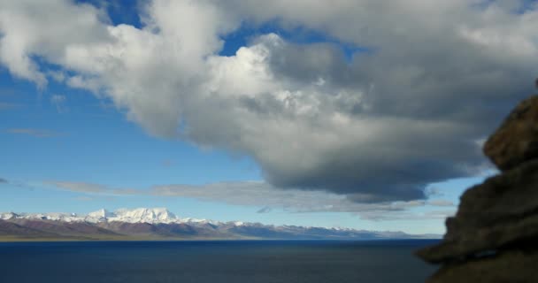 4k enormes nuvens massa rolando sobre lago namtso & montanha, budismo mani pedra . — Vídeo de Stock