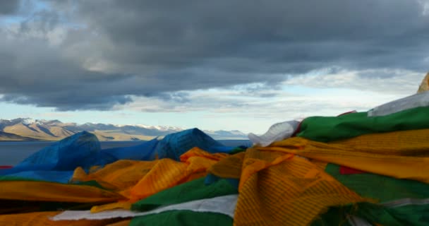 4k énorme masse de nuages roulant sur le lac namtso & montagne de neige, prier drapeau dans le vent . — Video