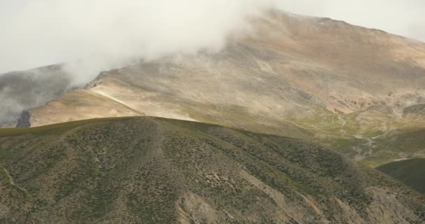 4k masa de niebla rodando sobre la cima de la montaña estéril del Tíbet, techo del mundo . — Vídeo de stock