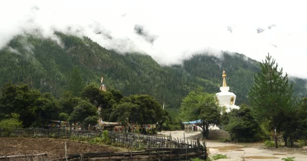 4k tibet people walking around buddhist white stupa in village. — Stock Video