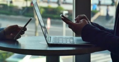 4k people using smartphone and laptop.city pedestrian and traffic window view.
