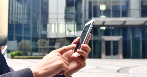 4k бізнесмен з мобільним телефоном або смартфоном біля офісної будівлі . — стокове відео