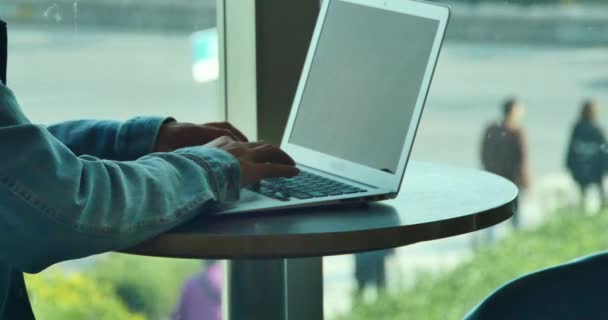 4k man working on laptop computer,city pedestrian and traffic window view. — Stockvideo