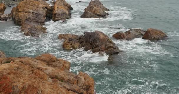 Yüzey ve kıyı rock sahil dalgalanma shore 4k okyanus deniz suyu köpüklü dalgalar. — Stok video