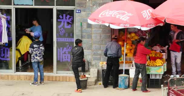 4k från gatan kan se ung flicka får en frisyr i tonsorial, shangri-la, Kina. — Stockvideo