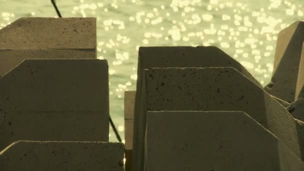 Dam steen, mousserende wateroppervlak en hengel, horizon. — Stockvideo