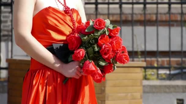 Bruid draagt een rode trouwjurk, uitvoering van een boeket van roze bloemen. — Stockvideo