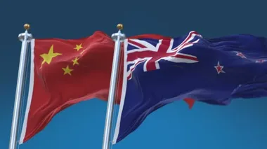 4k Dikişsiz Yeni Zelanda ve Çin Bayrakları mavi gökyüzü arka plan ile, Nzl Nz Chn Cn.