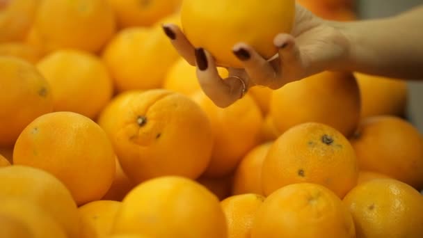 女性がスーパーでオレンジを選択します。 — ストック動画