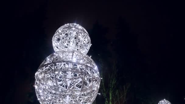 Snowman large glowing balls in the night snowy city — Stock Video
