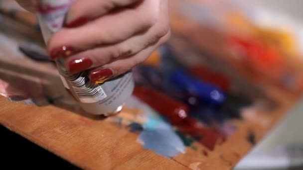 Jovem artista espreme tinta marrom na paleta — Vídeo de Stock