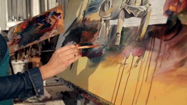 Un jeune artiste avec un pinceau et peint un tableau vivant — Video