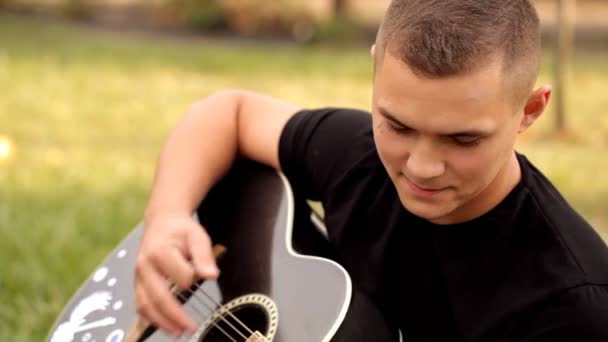 Giovane romantico in natura suona la sua ragazza alla chitarra — Video Stock