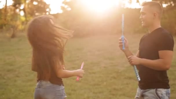 Par älskande blåser bubblor utomhus — Stockvideo