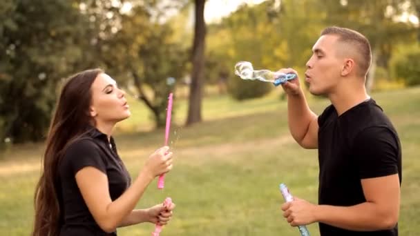 Pair of lovers blowing bubbles outdoors — Stock Video