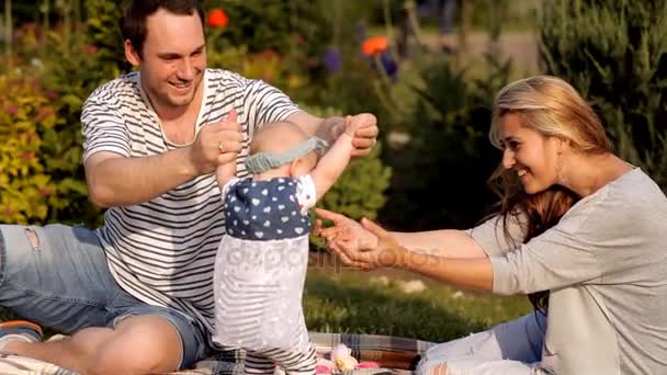 Jeune famille avec un enfant lors d'un pique-nique dans le parc — Video