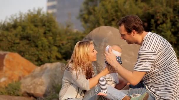 Los padres jóvenes juegan con un niño en un parque de vacaciones — Vídeo de stock