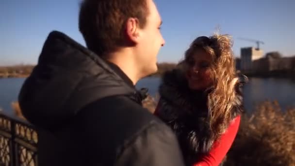 Junges Liebespaar spaziert am Damm entlang und bewundert den See — Stockvideo