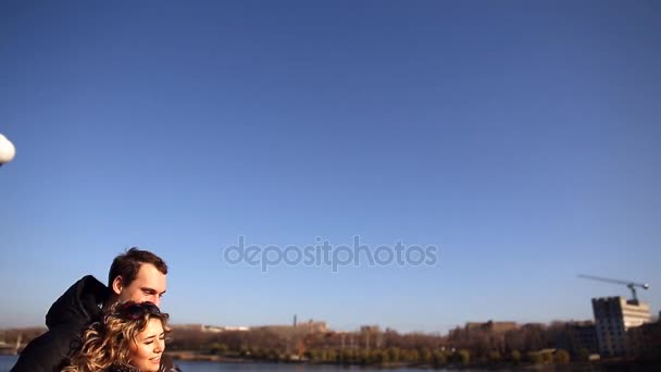 Jovem casal de amantes caminhar ao longo do dique e admirar o lago — Vídeo de Stock