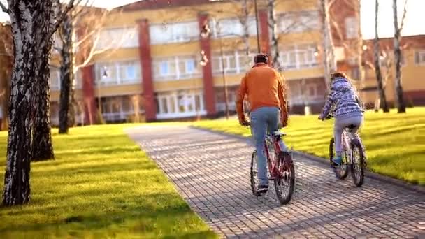 Joven pareja atlética monta su bicicleta en un parque de vacaciones — Vídeo de stock
