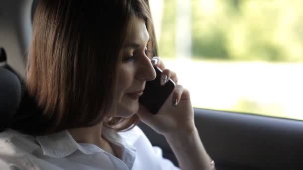 Maravilhosa menina de negócios monta em um táxi e falando ao telefone — Vídeo de Stock