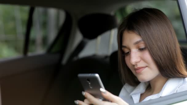 Wonderful business girl rides in a taxi and to use the phone — Stock Video