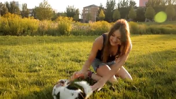 Söt tjej leker med sin hund på gräsmattan i parken — Stockvideo