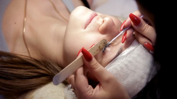 Make-up artist tar bort gamla ögonfransar till klienten, före bygga upp nya — Stockvideo