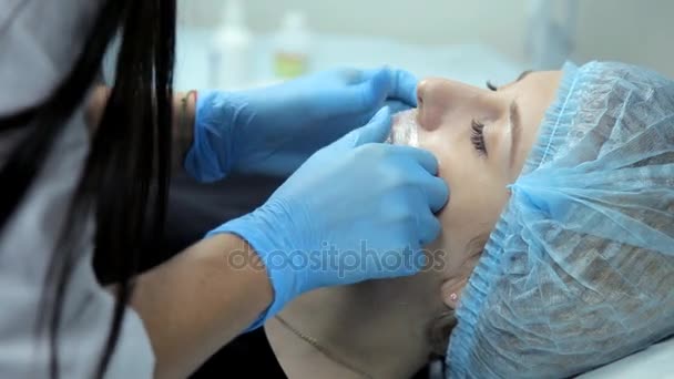 I skönhetssalongen förbereder den läkare-kosmetolog flickan att förfarandet för lip augmentation — Stockvideo