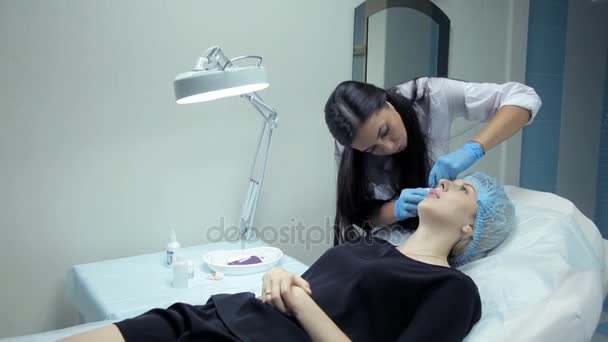 Klinikte, tıbbi bir güzellik uzmanı dudaklarını artırmak için bir kızla Botox enjekte — Stok video