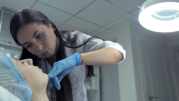 Klinikte, tıbbi bir güzellik uzmanı dudaklarını artırmak için bir kızla Botox enjekte — Stok video