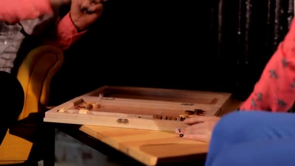 Två konstnärliga tjejer Spela backgammon i en restaurang — Stockvideo