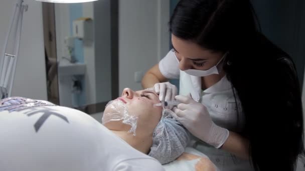 Косметолог робить клієнтську ін'єкцію гіалуронової кислоти для відновлення тканин шкіри. Процедура біоревіталізації — стокове відео