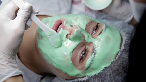 In the beauty salon the cosmetologist applies an alginate mask to the client — Stock Video