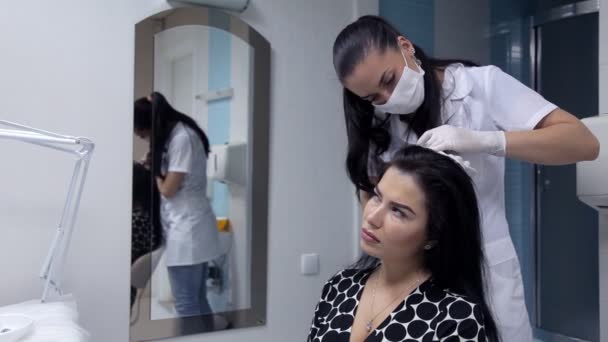En el salón de belleza el cosmetólogo hace inyecciones en la piel de la cabeza de las niñas con el fin de mejorar el estado del cabello. Procedimiento de mesoterapia del cabello — Vídeo de stock