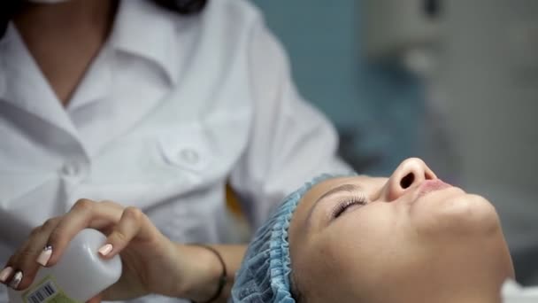 En el salón de belleza, el cosmetólogo prepara al cliente para los procedimientos — Vídeos de Stock