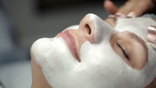 Il cosmetologo fa il massaggio di faccia al cliente in eccesso della maschera — Video Stock