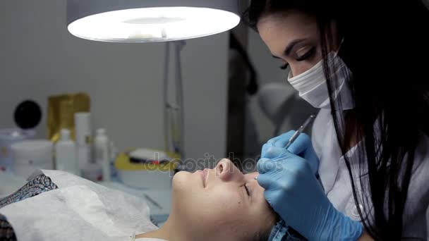 In de schoonheidssalon de schoonheidsspecialiste zorgt ervoor dat de client een mechanische gezicht schoonmaken — Stockvideo