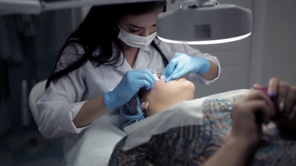 In the clinic, the cosmetologist does the client a mechanical facial cleansing — Stock Video