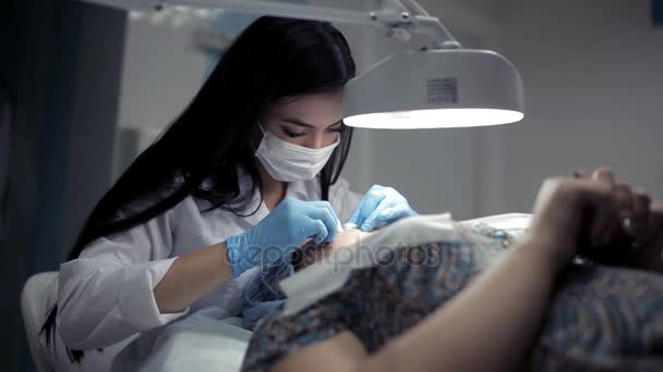 У клініці косметолог робить клієнту механічну чистку обличчя — стокове відео
