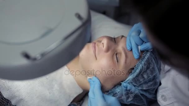 In the clinic, the cosmetologist does the client a mechanical facial cleansing — Stock Video